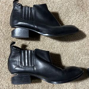 Rose gold notched heel black leather booties